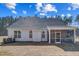 Rear exterior showcasing a screened porch, neutral siding, and lush backyard, offering a private outdoor space at 67 Rice Road # 01, Zebulon, NC 27597