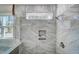 Shower with marble-style tile, a built-in niche, and a window view at 67 Rice Road # 01, Zebulon, NC 27597