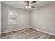Bedroom with wood-look flooring, neutral walls, and natural light from a large window at 7 Misty Creek Ct, Durham, NC 27705