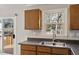 This kitchen features stainless steel sink, wooden cabinetry, and access to a deck through a sliding glass door at 7 Misty Creek Ct, Durham, NC 27705