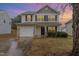 Charming two-story home featuring a stone-accented garage and manicured front yard at 702 Blue Lake Dr, Mebane, NC 27302