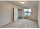 Neutral bedroom with plush carpet, a window with blinds, and a closet with double doors at 7727 Weathered Oak Way, Raleigh, NC 27616