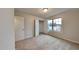 Bright bedroom features a large window, closet, and neutral carpet at 7727 Weathered Oak Way, Raleigh, NC 27616