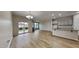 Open living room and kitchen area with light wood floors, granite breakfast bar, and sliding glass patio door at 7727 Weathered Oak Way, Raleigh, NC 27616