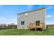 Home's rear facade showcases a deck and lawn beneath a bright, partly cloudy sky at 78 Fair Child Rd, Spring Lake, NC 28390