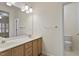 Bathroom features double sinks with wooden cabinets, a large mirror, and a toilet at 800 Mill Greens Ct, Raleigh, NC 27609