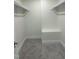 A walk-in closet featuring carpeted floors, white shelving, and a convenient bench seat at 812 Kenmore Ave, Louisburg, NC 27549