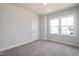 Bedroom with neutral carpet, white trim, large window, and modern ceiling fan at 88 Windchime Ct, Fuquay Varina, NC 27526