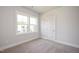 Bedroom with neutral carpet, white trim, large window, and two electrical outlets at 88 Windchime Ct, Fuquay Varina, NC 27526