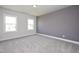Bedroom with neutral carpet, gray accent wall, white trim, and large windows at 88 Windchime Ct, Fuquay Varina, NC 27526