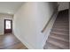 Hallway featuring a carpeted staircase with wooden handrail, leading to the upper level of the home at 88 Windchime Ct, Fuquay Varina, NC 27526