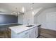 Kitchen island with stainless sink, faucet, quartz counters and open view of the dining area at 88 Windchime Ct, Fuquay Varina, NC 27526