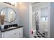 Updated bathroom features a modern vanity, a round mirror, and a shower-tub combo at 1005 W Club Blvd, Durham, NC 27701