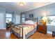 Comfortable bedroom with a metal bed frame, hardwood floors, and bright natural light through two large windows at 1005 W Club Blvd, Durham, NC 27701