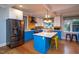 Open kitchen with island, stainless steel appliances, and bright contrasting cabinetry at 1005 W Club Blvd, Durham, NC 27701