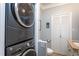 Convenient laundry area with stacked washer and dryer, utility sink, and ample storage space at 1005 W Club Blvd, Durham, NC 27701