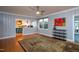 Open-concept living room features light-gray paneled walls, hardwood floors, a colorful rug, and bar access to kitchen at 1005 W Club Blvd, Durham, NC 27701