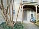 Exterior view of the entrance featuring a storm door, landscaping, and a bicycle at 1513 E Franklin St # C129, Chapel Hill, NC 27514