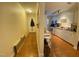 Galley kitchen featuring wooden floors, white cabinets and stainless steel appliances at 1513 E Franklin St # C129, Chapel Hill, NC 27514