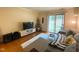 Bright living room featuring a comfortable gray couch, TV, neutral decor, and sliding glass doors to the patio at 1513 E Franklin St # C129, Chapel Hill, NC 27514