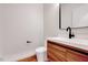 Half bathroom featuring a modern vanity, wood accents, and a sleek black faucet at 1604 Malta Ave, Raleigh, NC 27610