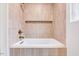 Clean white bathtub with tile surround, a shower head, and a recessed shelf at 1604 Malta Ave, Raleigh, NC 27610