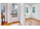 Hallway with hardwood flooring and natural light streaming through the glass doors and windows at 1604 Malta Ave, Raleigh, NC 27610