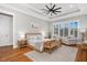 A serene bedroom featuring a woven bedframe, tray ceiling, wood floors, and bright natural light at 1804 Clifton Pines Dr, Cary, NC 27519