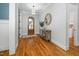 Warm and inviting foyer with hardwood floors, decorative mirror, and wooden front door at 1804 Clifton Pines Dr, Cary, NC 27519