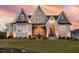 Striking two-story home featuring manicured lawn and architectural rooflines at sunset at 1804 Clifton Pines Dr, Cary, NC 27519
