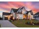 Elegant home featuring manicured landscaping, a brick and siding facade, and a curved driveway that leads to a garage at 1804 Clifton Pines Dr, Cary, NC 27519