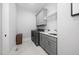 Well-equipped laundry room with gray cabinets, modern washer and dryer, and functional design at 1804 Clifton Pines Dr, Cary, NC 27519
