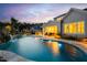 The luxurious pool area includes a rock waterfall feature, ample lighting, and mature landscaping for privacy and beauty at 1804 Clifton Pines Dr, Cary, NC 27519
