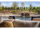 A backyard oasis with a pool featuring a rock waterfall, lush landscaping, and outdoor seating at 1804 Clifton Pines Dr, Cary, NC 27519