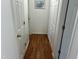 Hallway with wood floors and multiple closet doors, providing ample storage space at 1811 Kelly Glen Dr, Apex, NC 27502