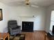 Spacious living room featuring a classic fireplace, ceiling fan, and hardwood floors for cozy, comfortable living at 1811 Kelly Glen Dr, Apex, NC 27502