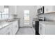Modern kitchen with white cabinets, granite countertops, and stainless steel appliances at 1912 Frost Dr, Haw River, NC 27258