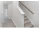 Bright staircase featuring carpeted steps, a white banister, and a sleek handrail at 1912 Frost Dr, Haw River, NC 27258