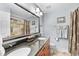 Bathroom featuring double sinks, granite countertops, framed mirror, and tiled walk-in shower at 204 Brittany Pl, Cary, NC 27511