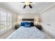 Inviting bedroom featuring a ceiling fan, a king size bed with decorative blue pillows, and large windows at 204 Brittany Pl, Cary, NC 27511