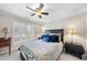 Cozy bedroom featuring ceiling fan, plantation shutters, and a plush bed with decorative blue pillows at 204 Brittany Pl, Cary, NC 27511