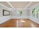 Dining room featuring hardwood floors, wainscoting, modern light fixture and natural light at 204 Brittany Pl, Cary, NC 27511