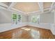 Dining room featuring hardwood floors, wainscoting, modern light fixture and natural light at 204 Brittany Pl, Cary, NC 27511
