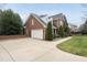 The exterior showcasing a brick home with a two car garage and well maintained lawn at 204 Brittany Pl, Cary, NC 27511