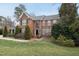 Beautiful two-story brick home with a well-manicured lawn and mature trees at 204 Brittany Pl, Cary, NC 27511