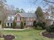 Classic brick facade with manicured lawn, white framed windows, black shutters, and mature landscaping at 204 Brittany Pl, Cary, NC 27511