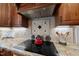 Modern kitchen featuring granite countertops, backsplash, range hood, and stainless steel appliances at 204 Brittany Pl, Cary, NC 27511