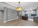 A spacious open kitchen with modern lighting, gray cabinets, wood floors and a breakfast bar with seating at 204 Brittany Pl, Cary, NC 27511