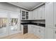 Kitchenette with white cabinets, black countertops, wine cooler, and easy access to a deck at 204 Brittany Pl, Cary, NC 27511