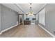 Neutral living room with hardwood floors featuring kitchen and dining area with shuttered window at 204 Brittany Pl, Cary, NC 27511